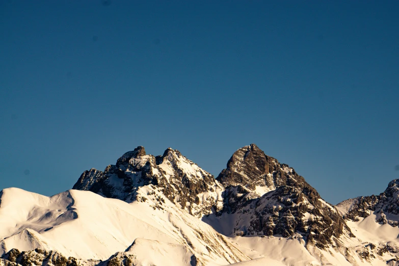 a group of snow capped mountains with blue sky