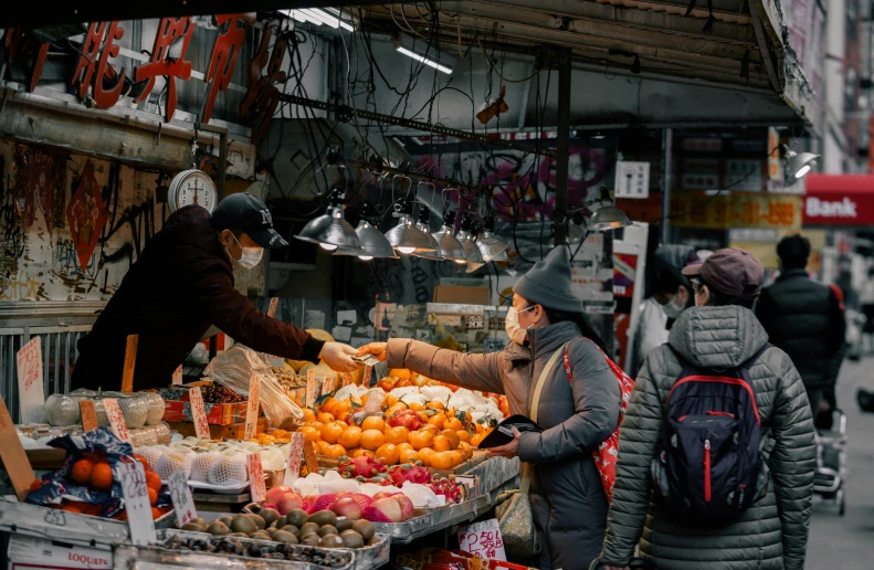 people shopping in the outdoor market for fresh produce