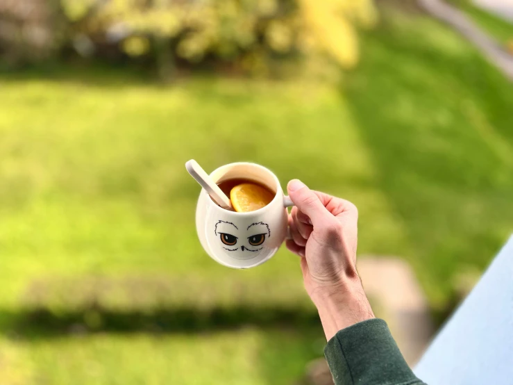 someone holding a coffee cup that looks like an angry face