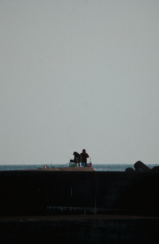 two people sitting on a bench looking out over the water