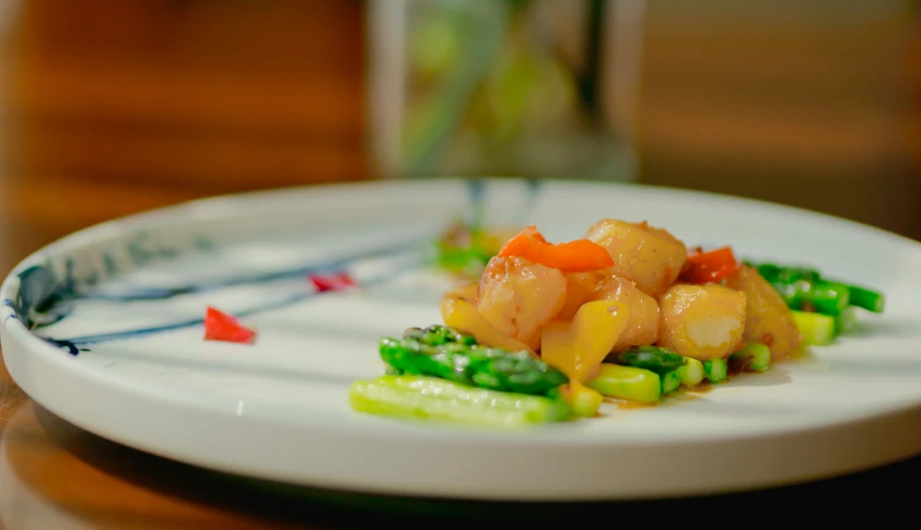 a plate of food with shrimp, asparagus and vegetables on it