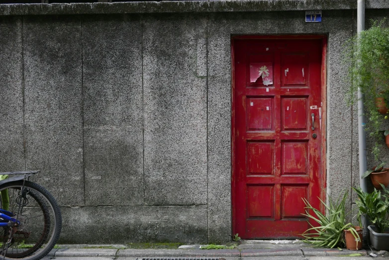 a bike is parked next to a red door