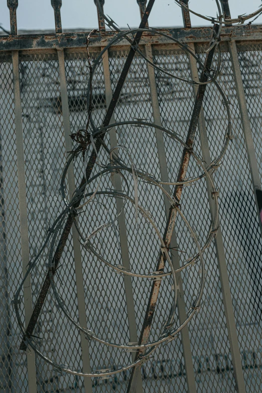 the power lines are tangled by chains on top of a fence