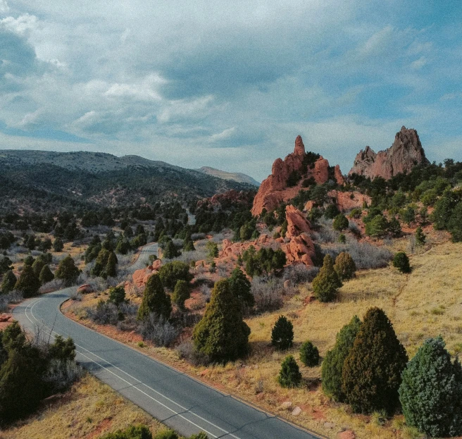 the mountains near a road are surrounded by trees