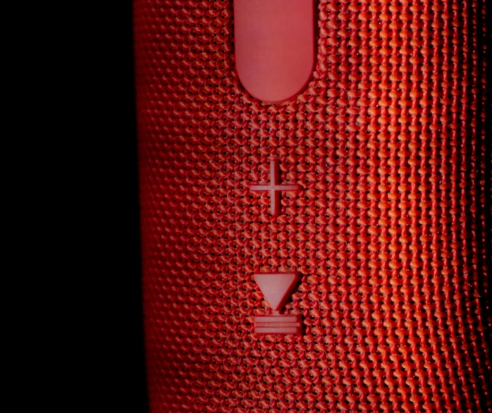 a close up of the bottom half of a red speaker