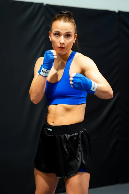 female professional boxing player in blue crop top with blue gloves