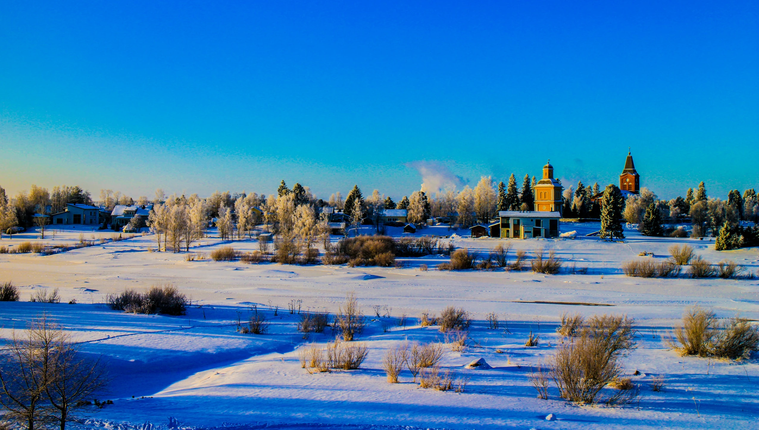 this is a snowy and scenic view of a town in the background