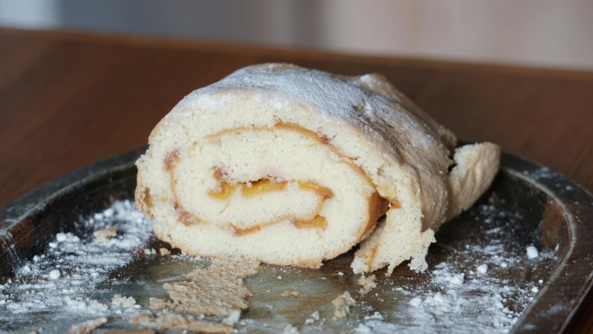 a partially eaten pastry sitting on top of a black plate