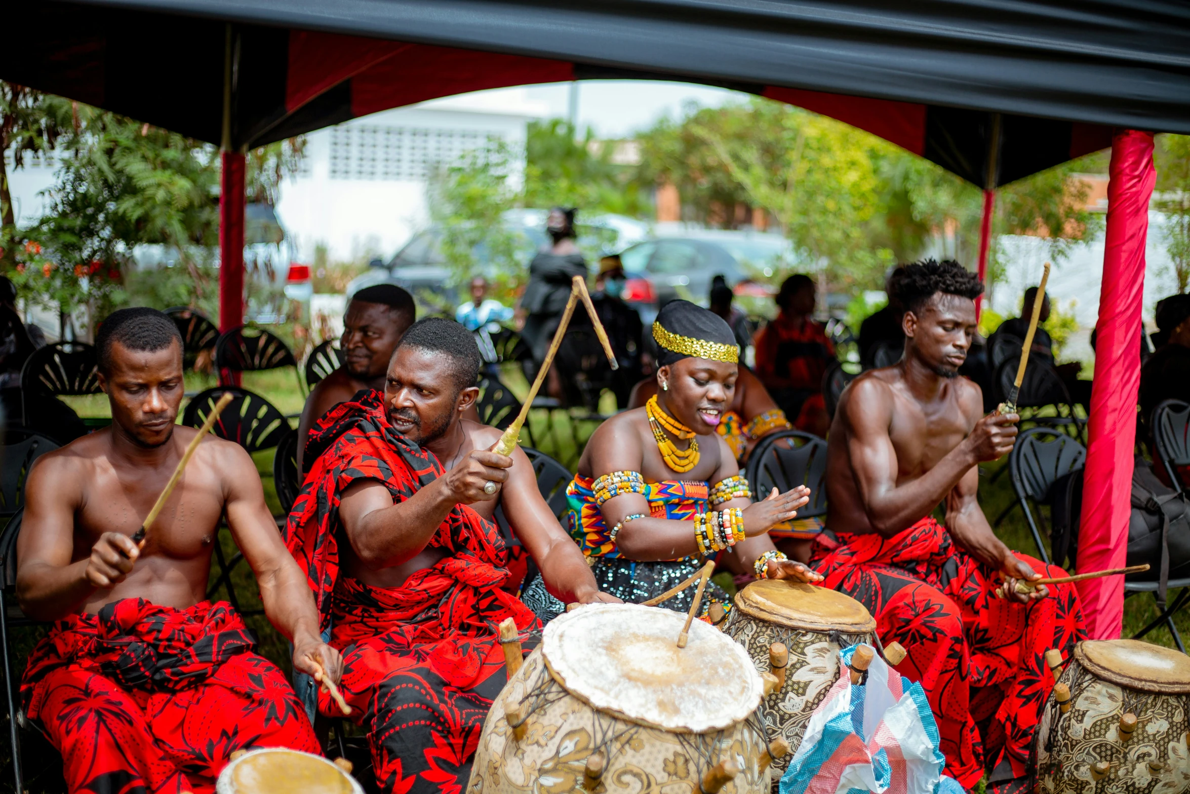 some black men sitting with drums and drumming instruments