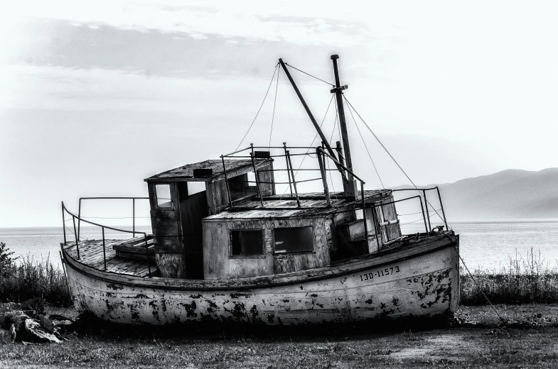 an old boat sitting on the beach at dusk