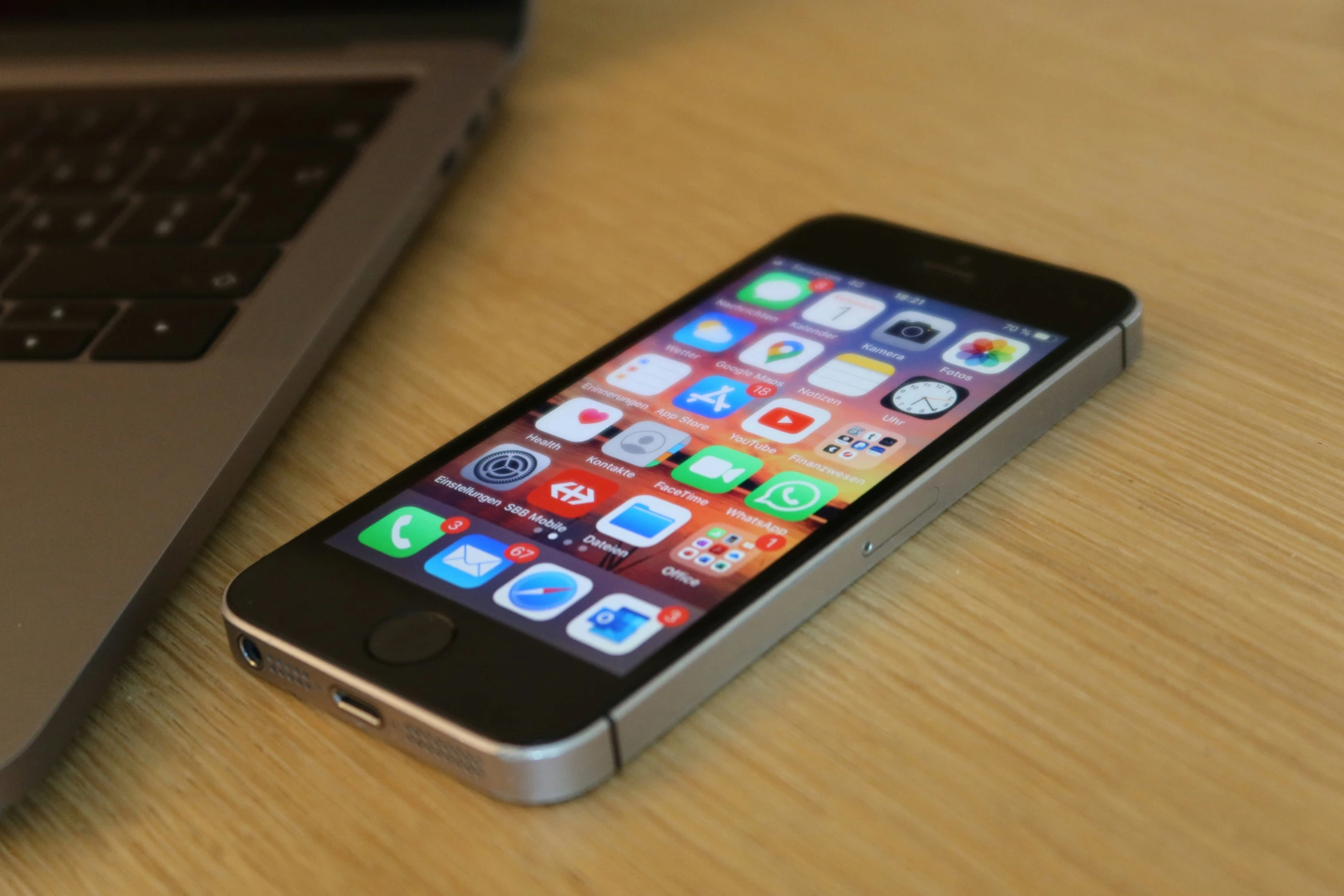 an iphone sitting on a table next to a laptop