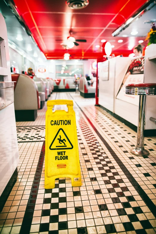 a caution sign sits on the floor of a restaurant