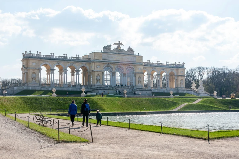 two people walking through the grounds outside a palace