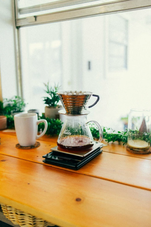 a coffee pot and glass mugs on a counter