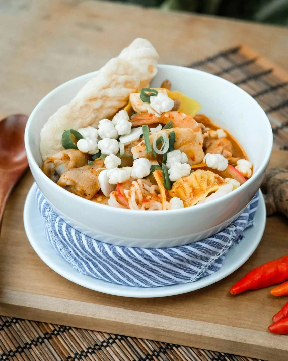 a white bowl filled with lots of food next to two peppers