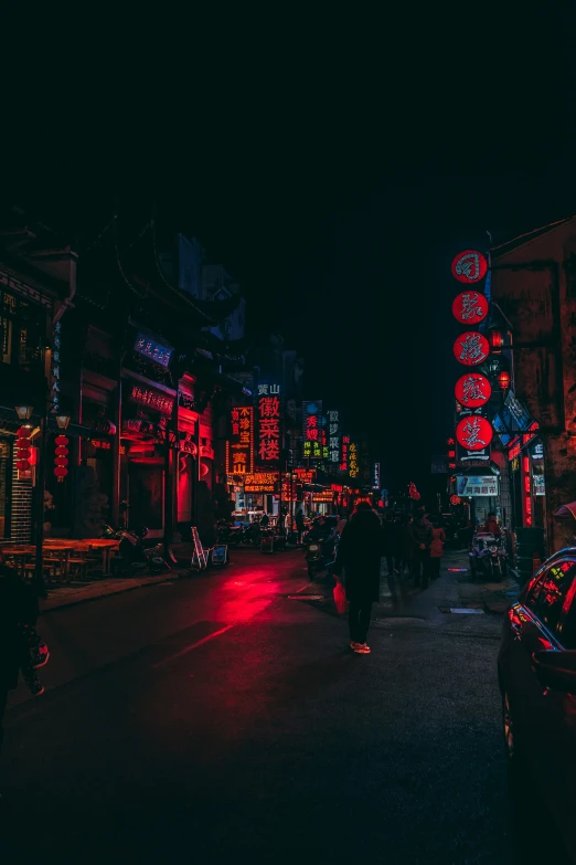 an alley with neon signs at night in the city