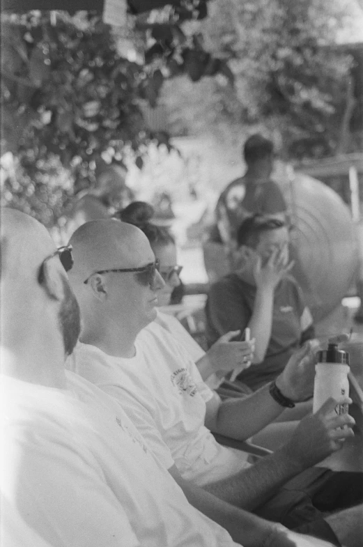 a woman sitting down while two men talk