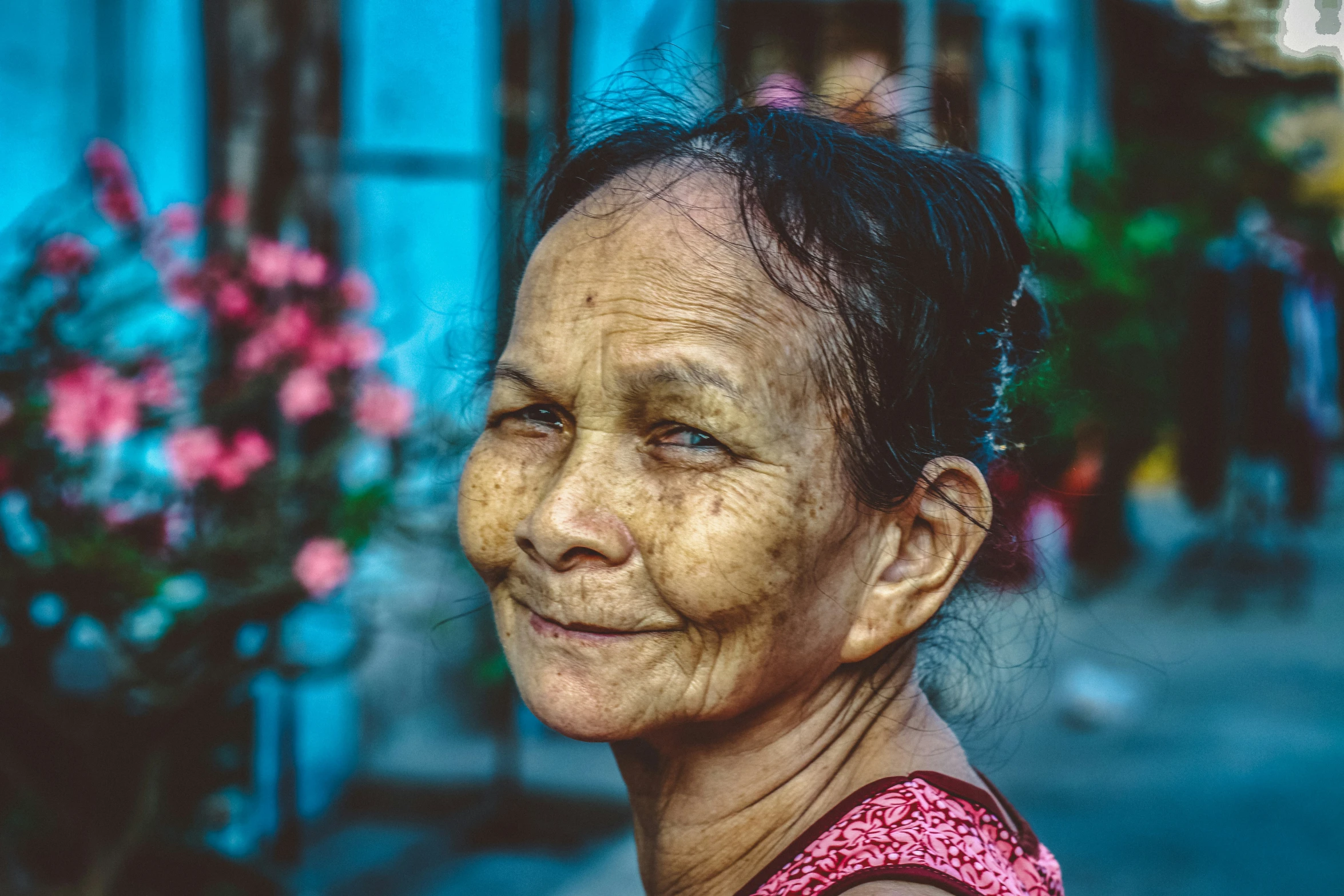 a woman that is standing in front of some flowers