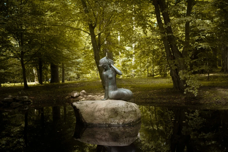 an individual statue that is sitting on top of a rock