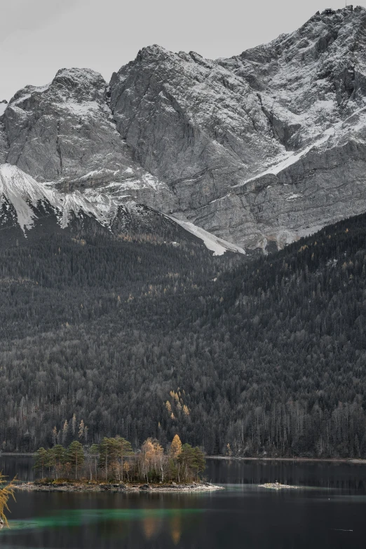 the mountains are covered in snow, with a body of water