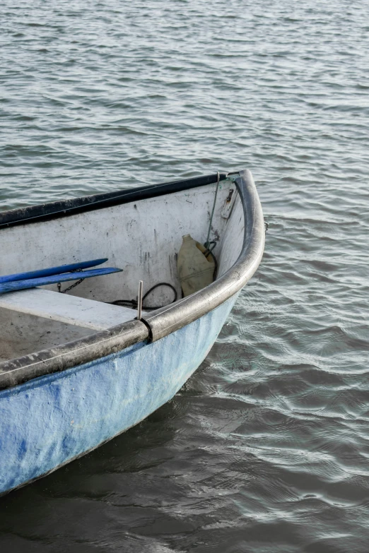 an empty blue and white boat in a lake