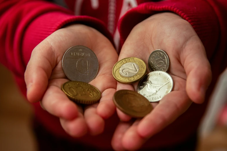 a person is holding out their hands with some coins