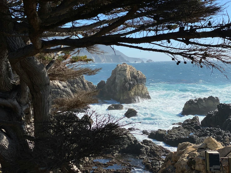 this view looks down on the ocean and rocky shore