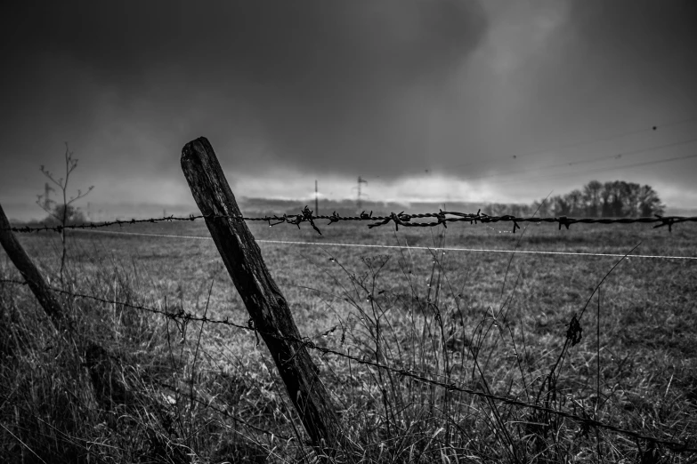 an old fence in the country on a cloudy day