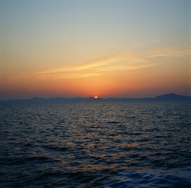 the sun is setting over the ocean with waves