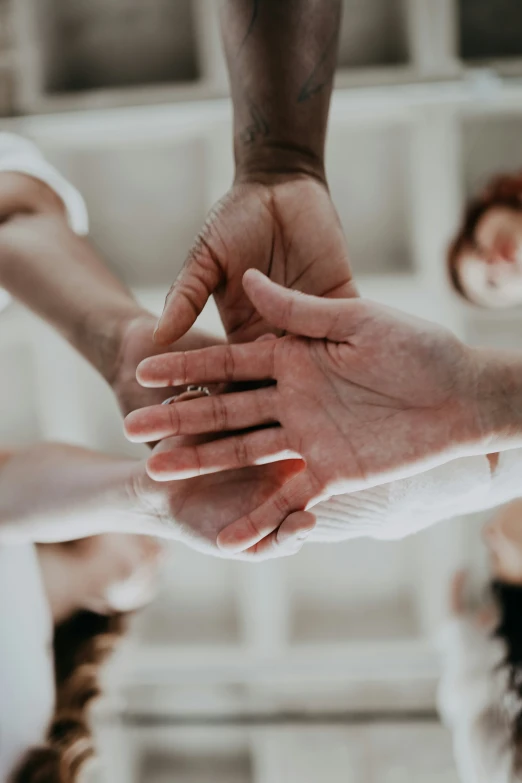 several hands are stacked on top of each other