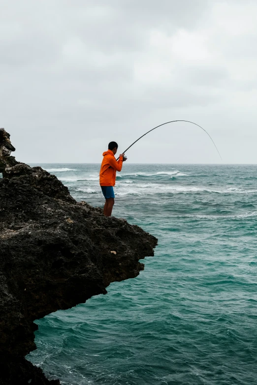 a person holding a fishing rod by the water