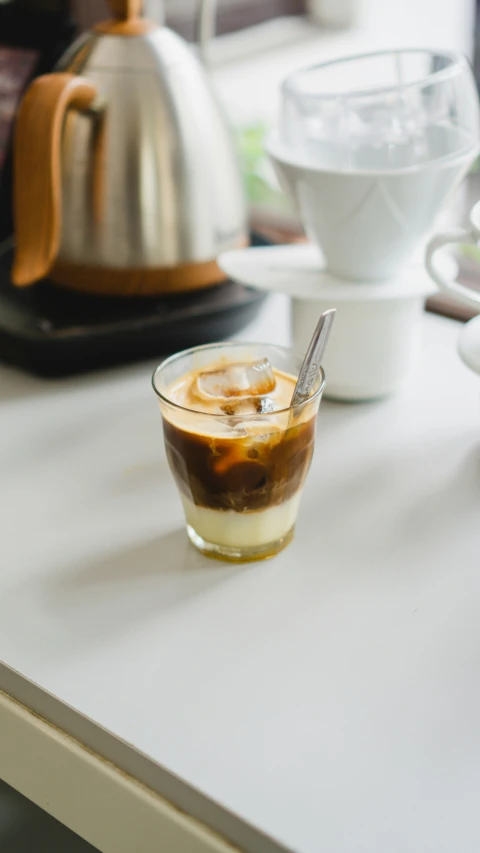 a glass filled with liquid sitting on top of a white table