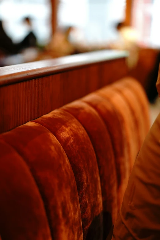 the seats of a restaurant are brown with red velvet