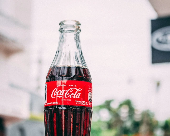 a bottle of coca cola sitting on a window sill