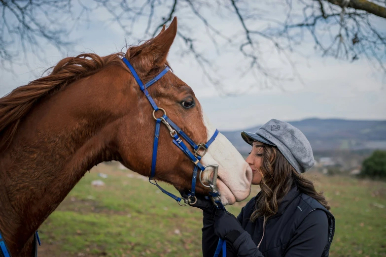 a woman holding the head of a horse