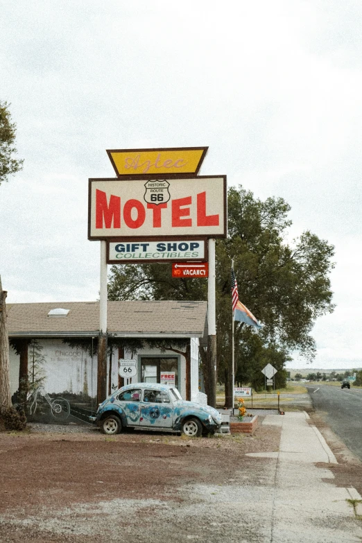 a vintage car parked in front of a motel