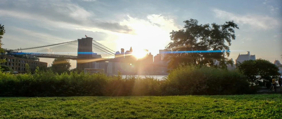 a bridge in a city at sunrise over a river