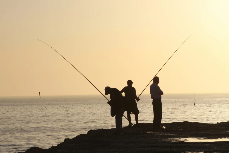 two people on the rocks with fishing rod