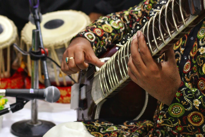 a man in a colorful dress playing an instrument