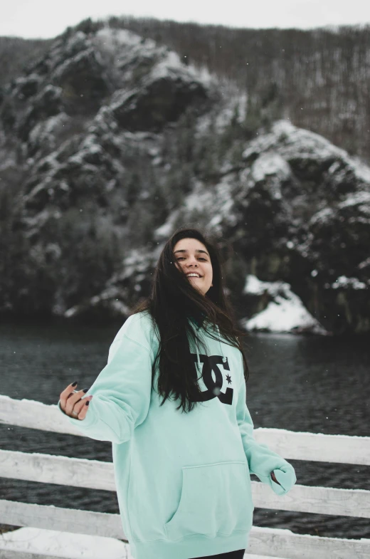 a young woman poses in front of a snowy mountain