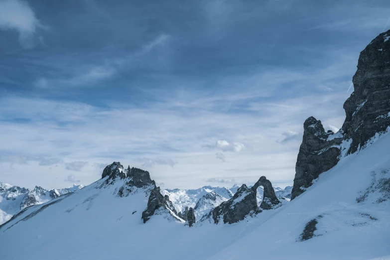 a lone skier on top of a mountain with no snow