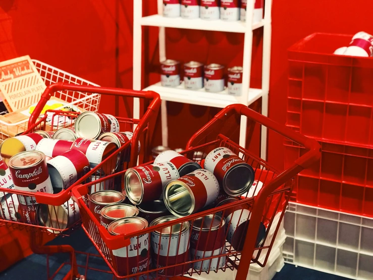 a shopping cart filled with soda cans in a red kitchen