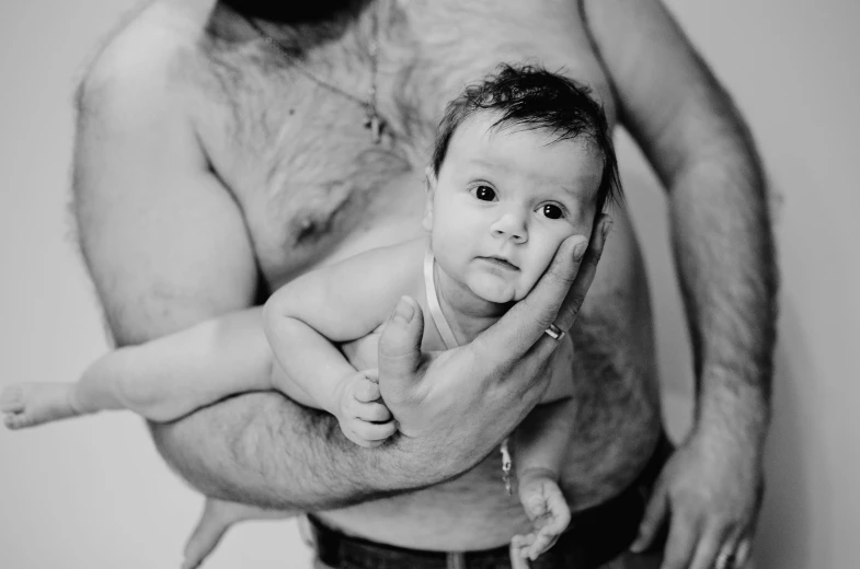a man holding his baby in his arms