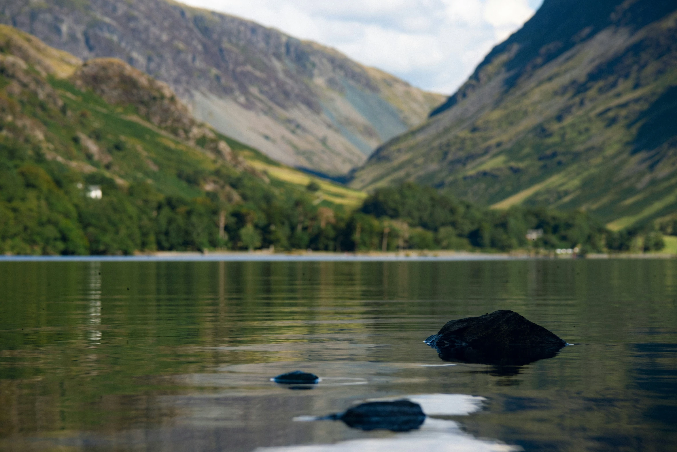 rock floating on surface of lake near mountains