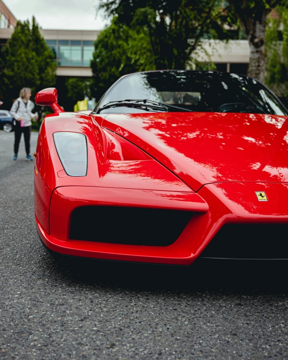 red sports car with two people walking by