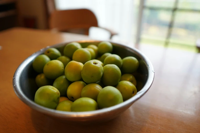 a bowl with a bunch of green apples in it