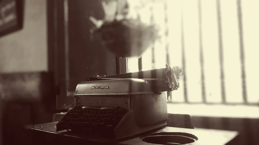 an old fashioned typewriter on a table near some blinds