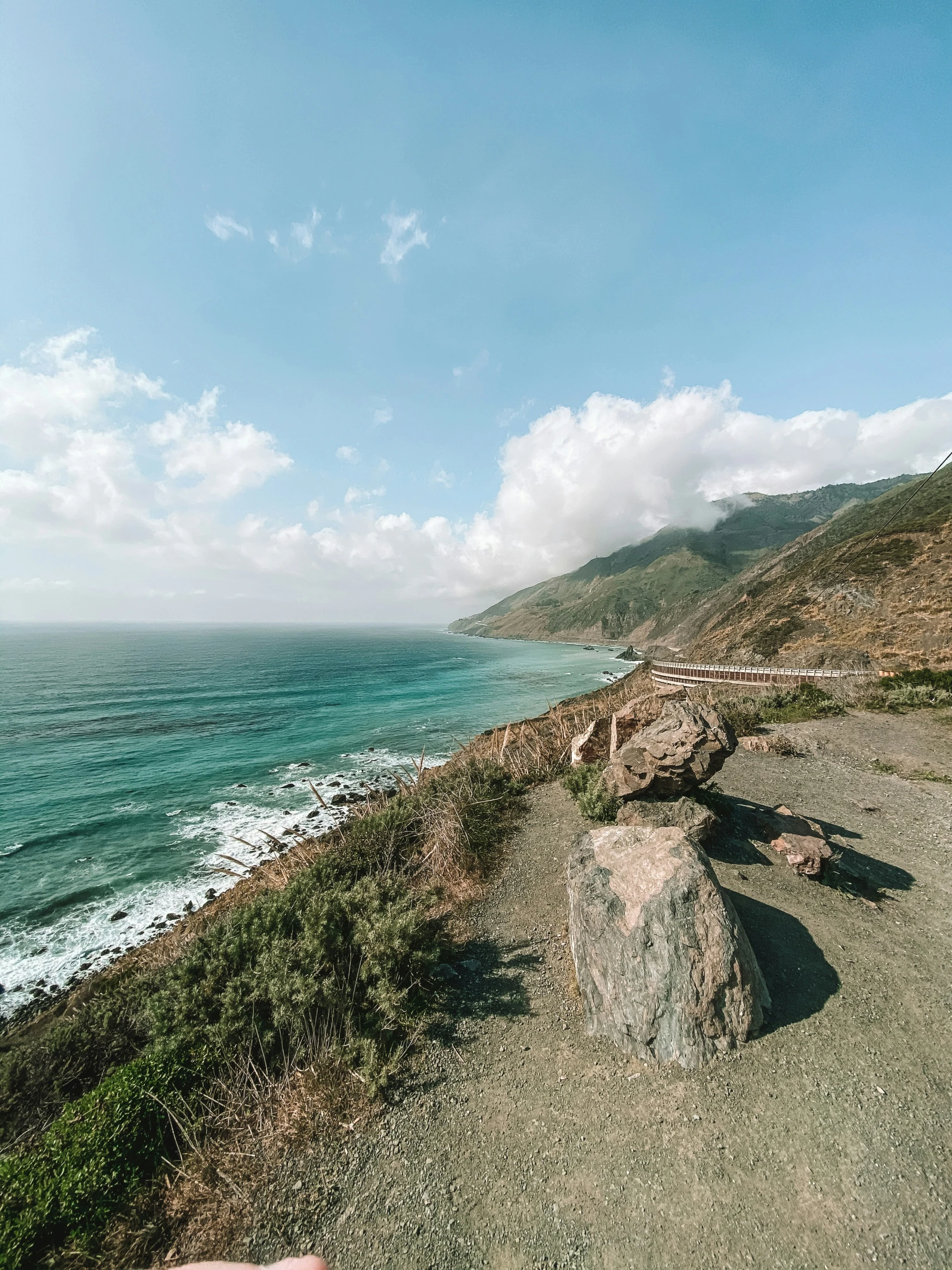 a person is riding a skateboard on a hill by the ocean