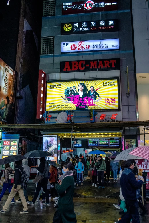 a city scene with pedestrians and signs on it at night