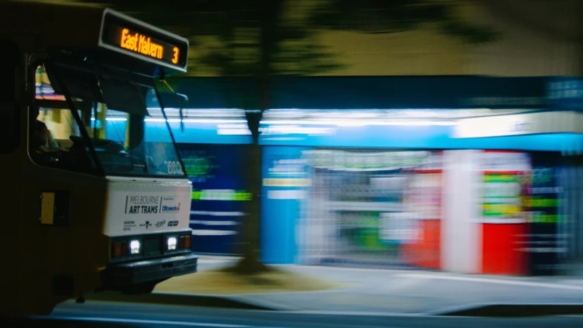 an orange bus is riding down the street